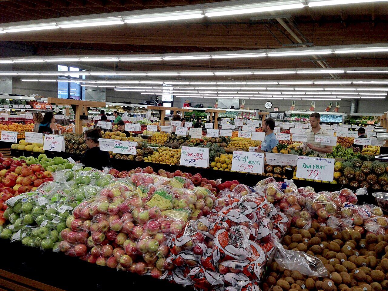 Produce section of Berkeley Bowl with vegetables and price labels