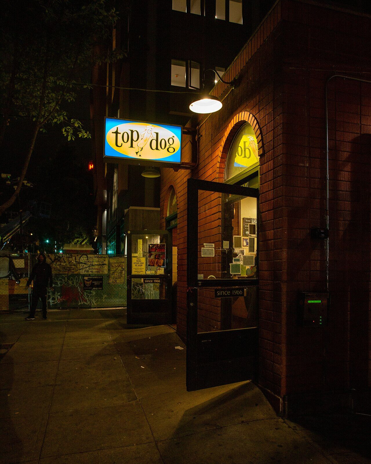 Top Dog storefront at night on Durant Avenue with neon sign